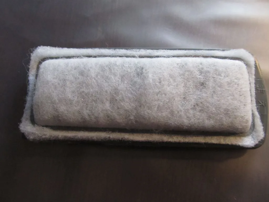 A rectangular hang-on filter cartridge with white filter floss held in a plastic frame